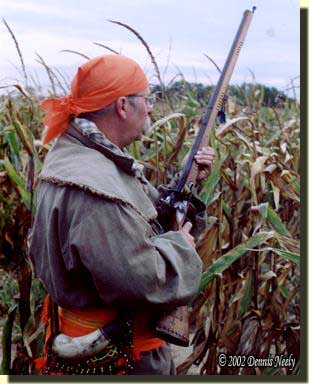 A traditional woodsman at the edge of a cornfield.
