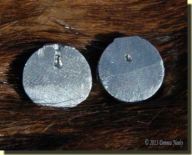 Two light cast lead balls with air pockets.