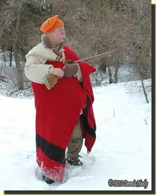 A traditional woodsman wearing a four-point trade blanket.