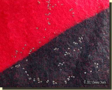 Sticktights dot the tail of a red-wool trade blanket