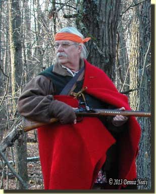 A traditional woodsman, clad in a trade blanket, looks back.