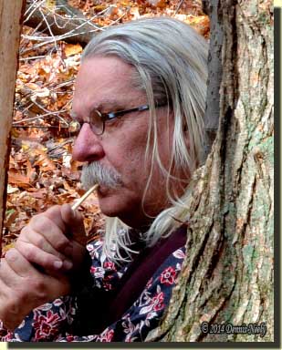 A traditional woodsmanmaking a turkey cluck with a wing-bone call.