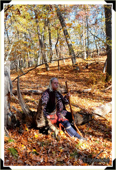 A traditional woodsman sitting on a log on a warm fall afternoon.