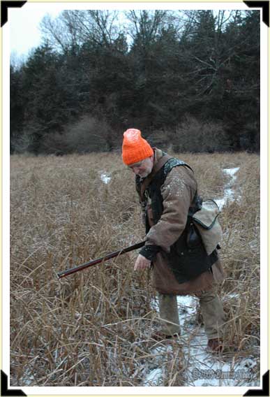 A French hunter tracking a deer across a swamp.