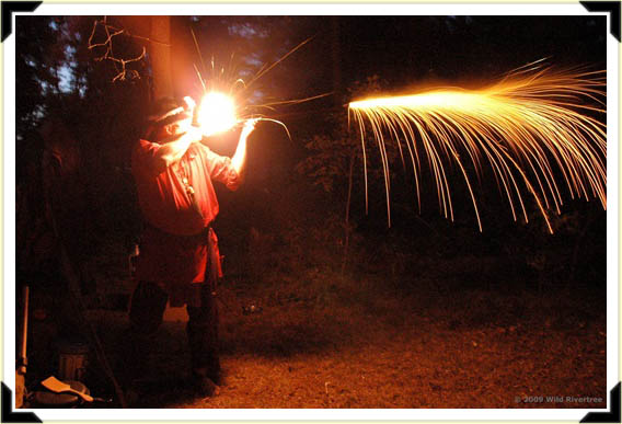 Fire from the muzzle as a traditional woodsman discharges his gun.