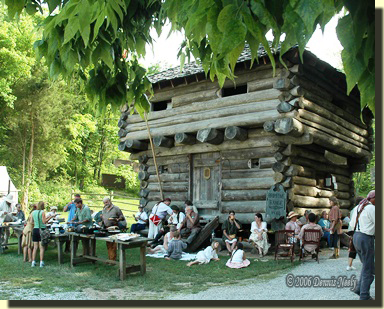 a frontier barbecue held beside a block house.